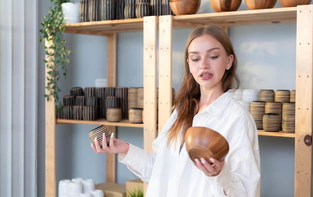 Young female runs a small business making clay jewelry Presented to customers with products via