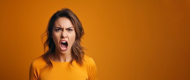 Foto giovane femmina che urla con espressione facciale di rabbia su sfondo arancione copia lo spazio per il testo