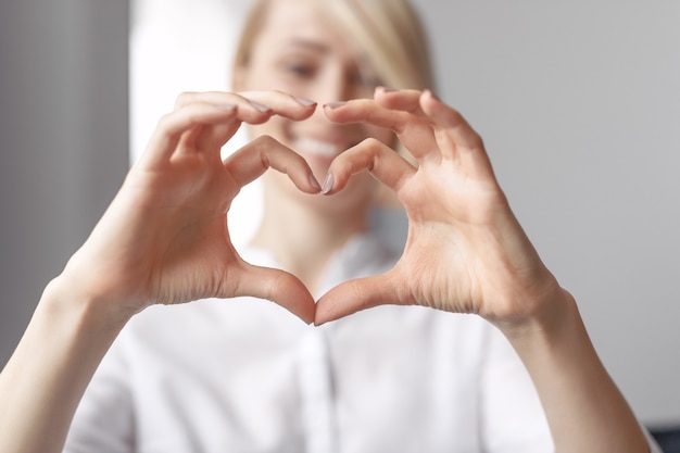 Young female showing a shaped heart with her hands