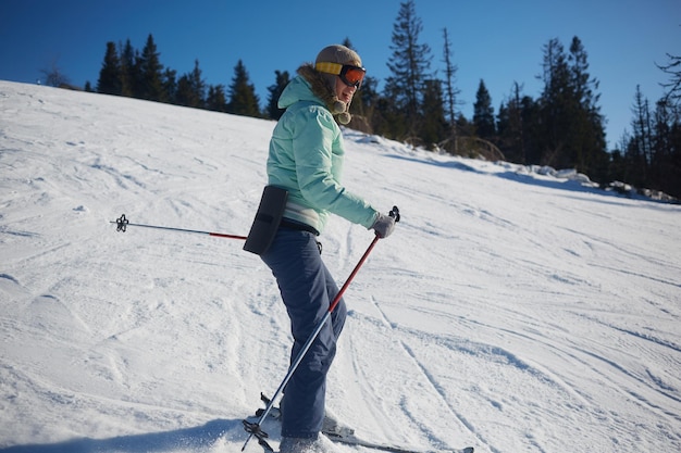 The young female skier in downhill slope