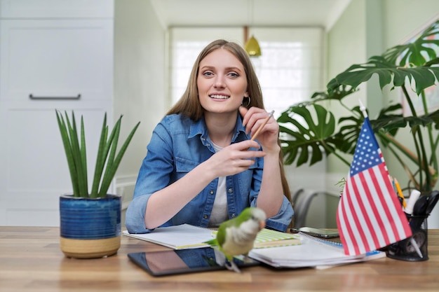 Young female student looking at the camera usa flag on the table