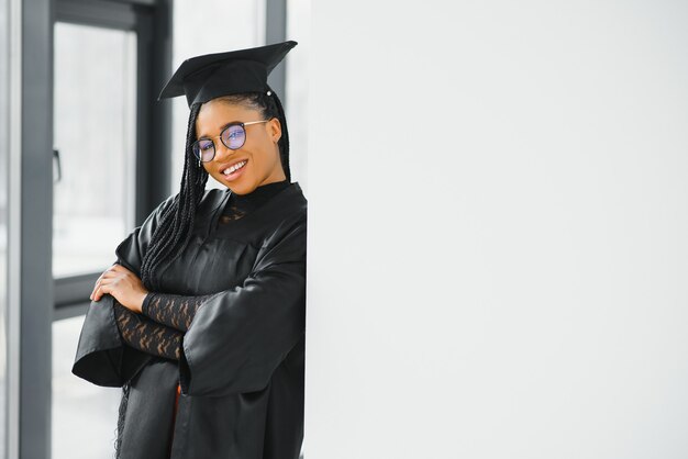 Young female student in robe celebrating her graduation