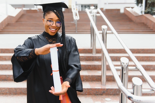 Young female student in robe celebrating her graduation