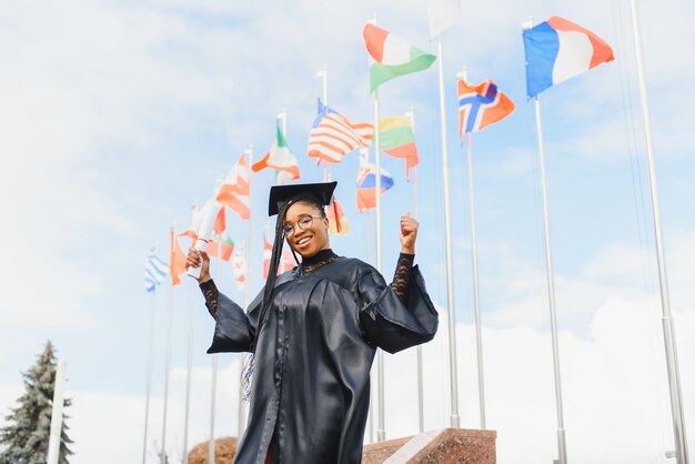 Young female student in robe celebrating her graduation