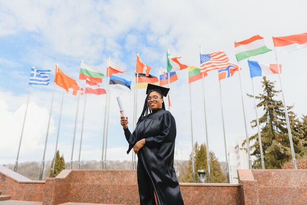 Young female student in robe celebrating her graduation