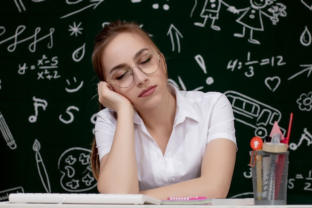 Young female student sleeping in a classroom