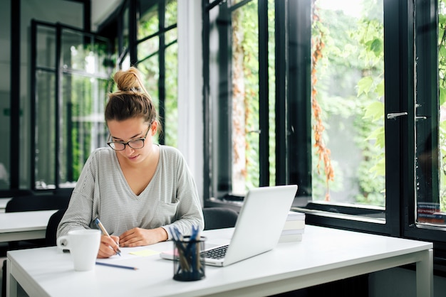 Young female student studying in library.