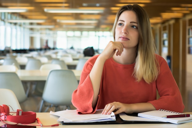 図書館で勉強している若い女子学生。