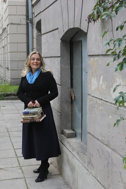 Photo a young female student with blond hair and a bag of books in her hands