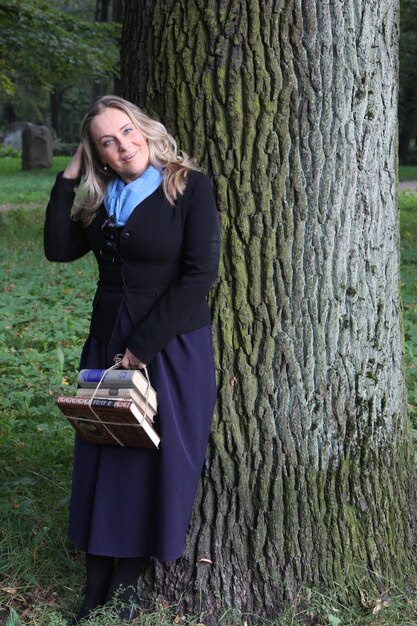 A young female student with blond hair and a bag of books in her hands