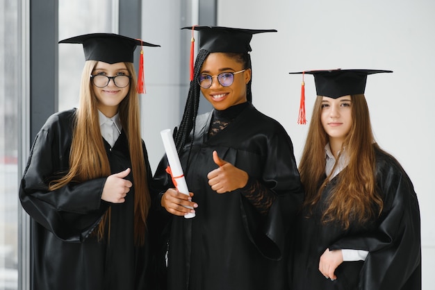 Young female students in robe celebrating their graduation