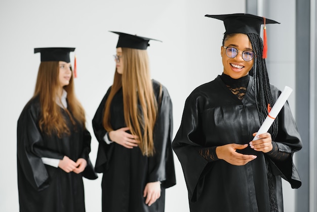 Young female students in robe celebrating their graduation