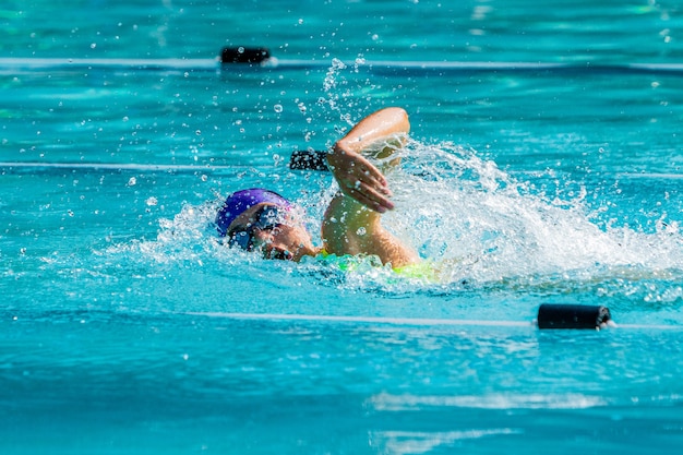 若い女子水泳選手がフリースタイルで泳ぐ