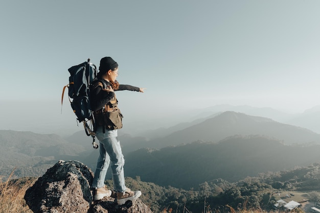 Young female tourist carrying luggage at sunset