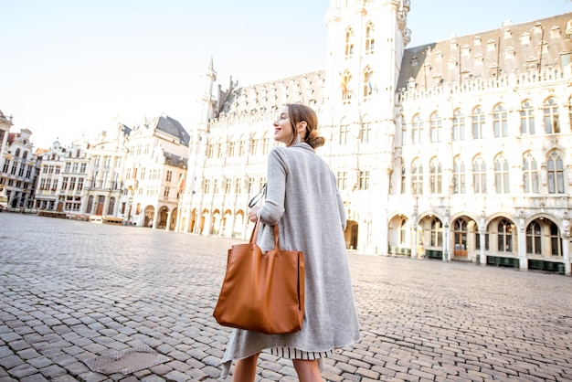 Young female tourist walking on the main square with city hall in the old town of Brussels in Belgium