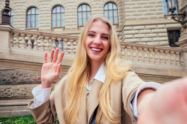 Young female tourist with czech flag wawing near fountain Wenceslas Square.