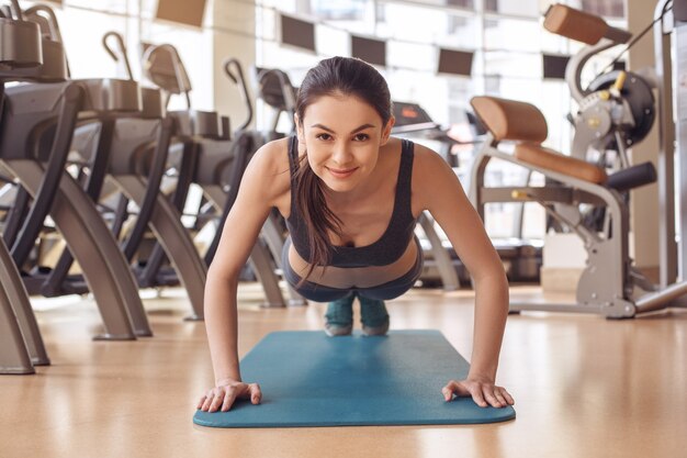 Young female training in gym healthy lifestyle exercise on yoga mat