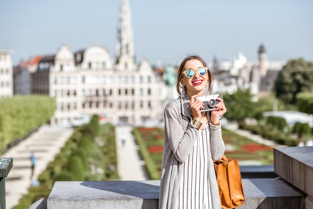 写真 ブリュッセルの旧市街の素晴らしい景色を望む有名な芸術山にフォトカメラで立っている若い女性旅行者