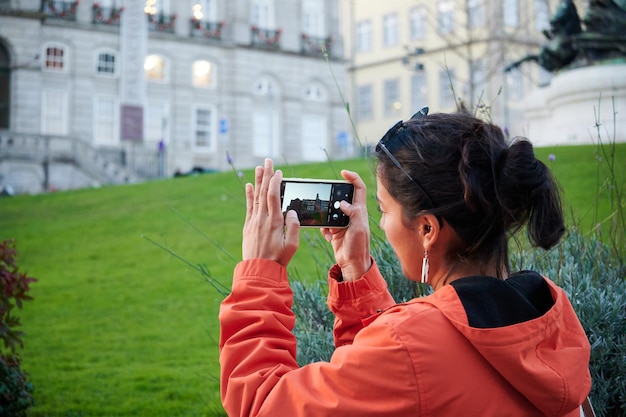 昼間に建物の写真を撮る若い女性旅行者