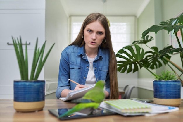 Young female university student studying online using video communication