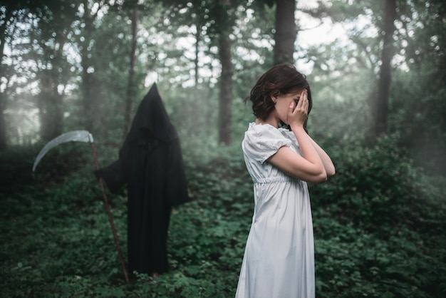 Young female victim in white dress in the forest