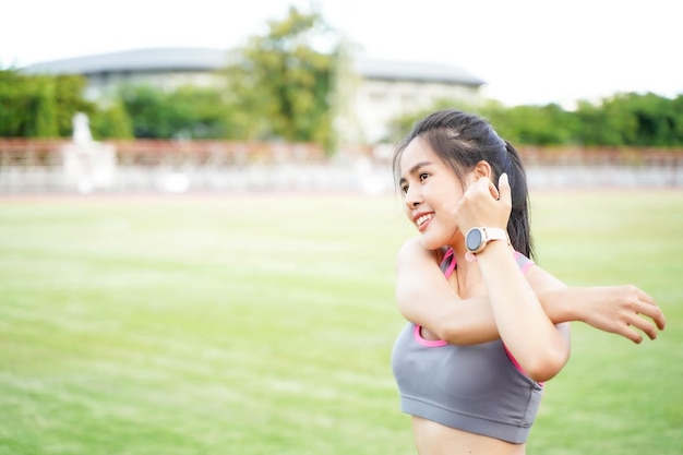 Young female warm up outdoor morning before workout and jogging at the football stadium