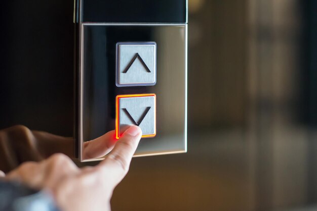 Photo young female was using her finger to press on the elevator botton down in office building