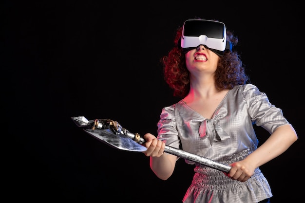 Young female wearing vr headset with battle axe on dark surface warrior vikings samurai