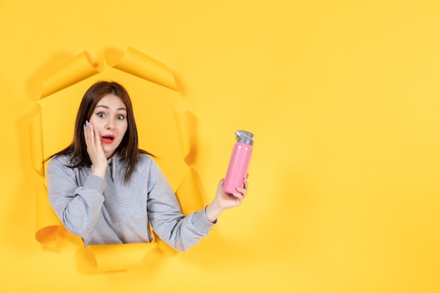 young female with bottle of water on yellow paper background athlete fit indoor