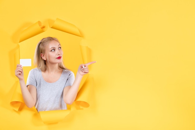 Young female with credit card on yellow background money sale shopping