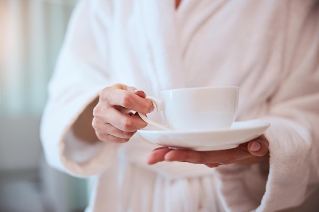 ハーブ飲料のカップを持つ若い女性