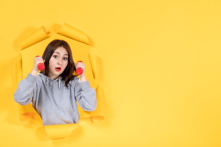 Photo 年轻的女性用<unk>杆在撕裂的黄色纸背景运动适合健身房运动员