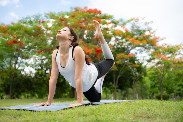 Young female with outdoor activities in the city park Yoga is her chosen activity