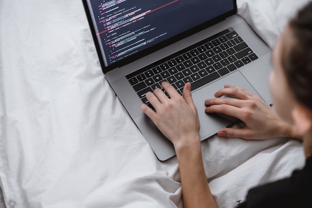 Young female writes program code on a laptop