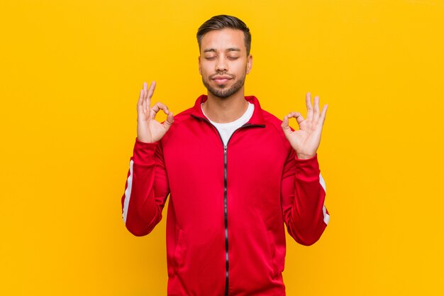 Il giovane uomo filippino di forma fisica si rilassa dopo la dura giornata di lavoro, sta eseguendo lo yoga.