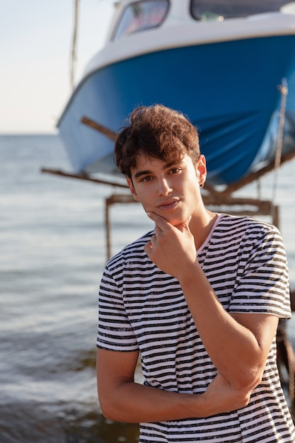 Young fisherman posing near fisher boats