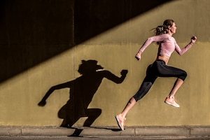 Young fit blonde woman jumping in the street