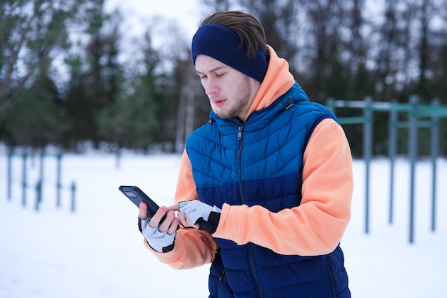冬の寒い雪の日に外でトレーニングをしている若い男性 健康的なフィットネスライフスタイル