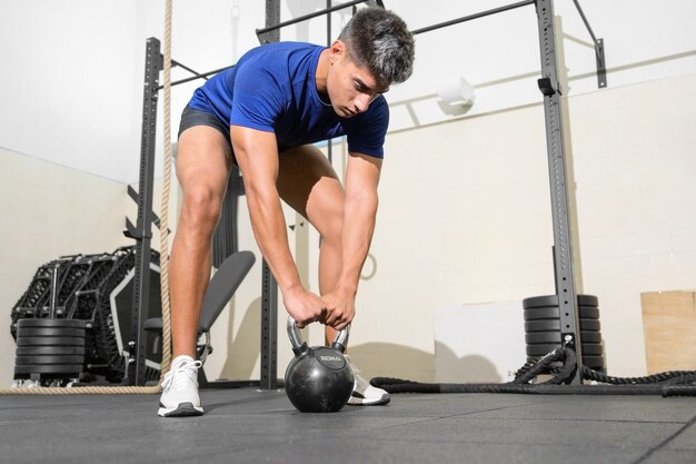 Young fit man training with kettlebells