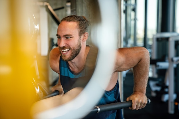 Young fit muscular man during workout in the gym