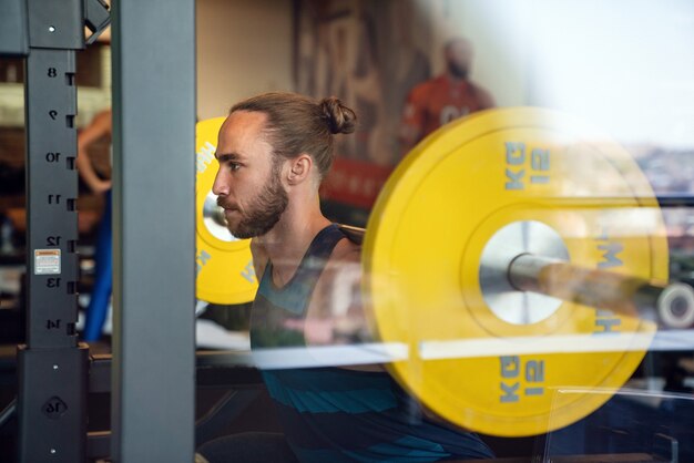 Young fit muscular man during workout in the gym