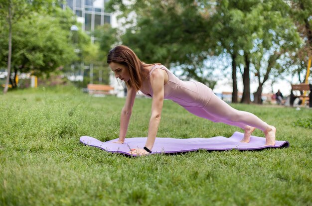 Young fit woman doing pushups in the park Healthy lifestyle