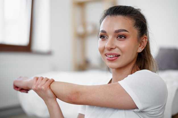 自宅でストレッチ体操をしている若いフィットの女性