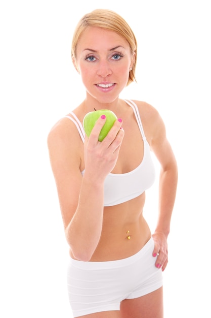 a young fit woman with a green apple over white