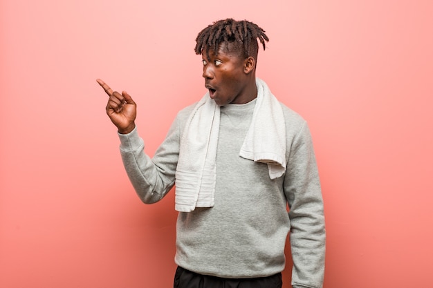 Young fitness african black man pointing to the side