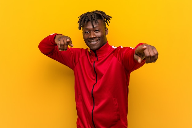 Young fitness african man cheerful smiles pointing to front.