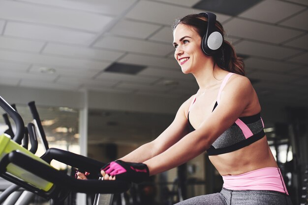 Young fitness girl doing exercises on the machine at the gym