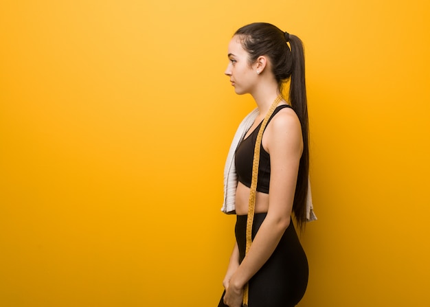 Foto giovane ragazza di forma fisica sul lato cercando di fronte