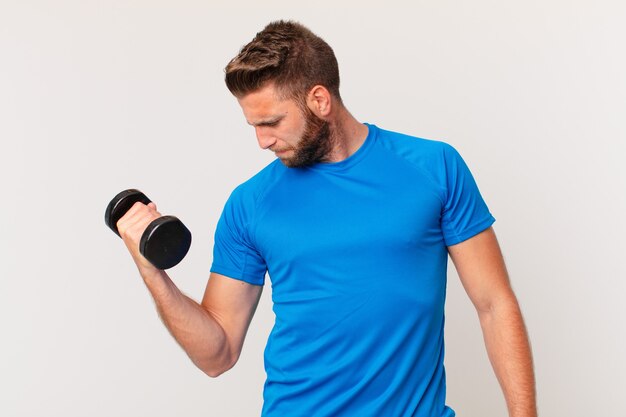 Young fitness man lifting a dumbbell