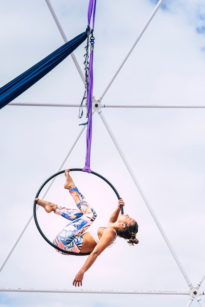 Foto l'atleta della ragazza della gente del corpo perfetto di forma fisica giovane fa gli esercizi aerei con un cerchio